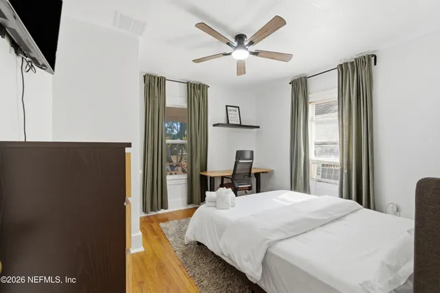 a bedroom with a large bed and a flat tv screen