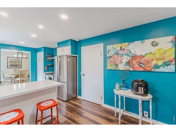 a kitchen with stainless steel appliances kitchen island granite countertop a refrigerator and a dining table
