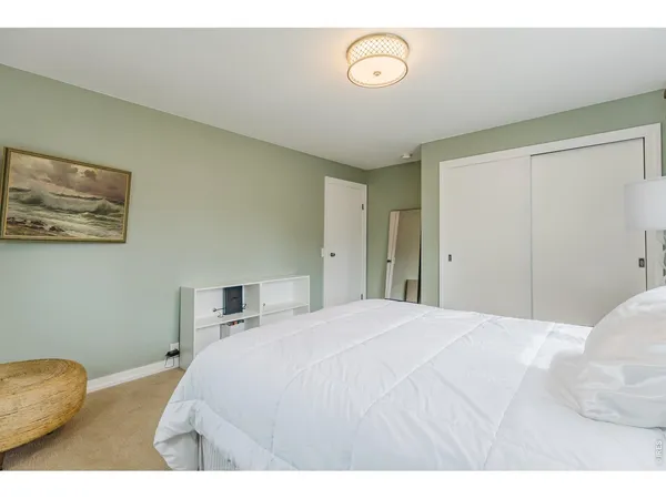 a bedroom with a bed and a painting on the wall