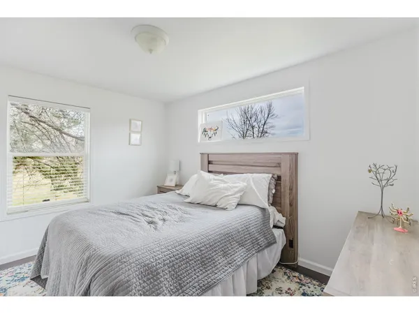 a bedroom with a large bed and a painting on the wall