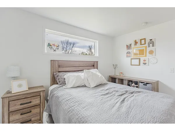a bedroom with a bed and painting on the wall