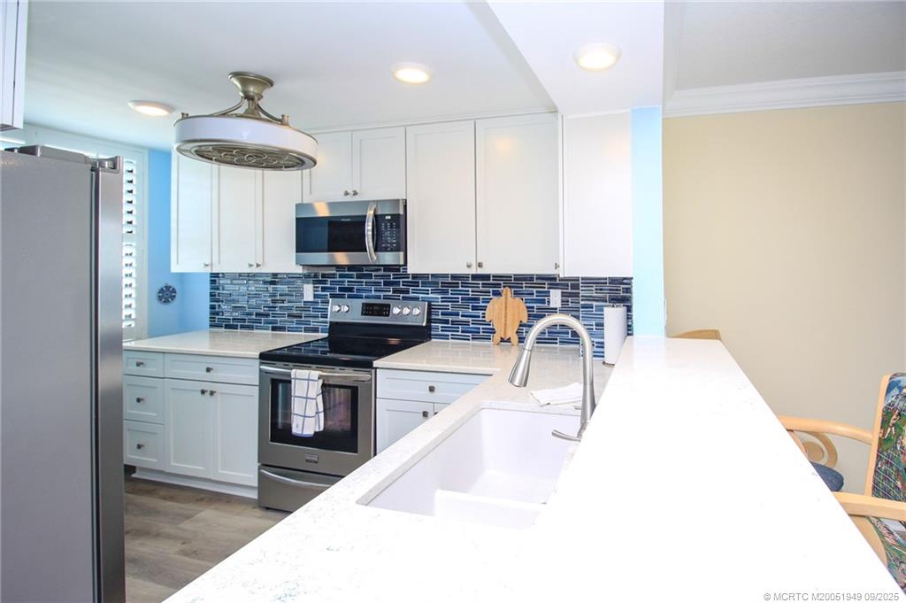 10680 South Ocean Drive, Unit 705 Jensen Beach, FL 34957 - Photo 13 of 45 a kitchen with a stove a sink and a refrigerator