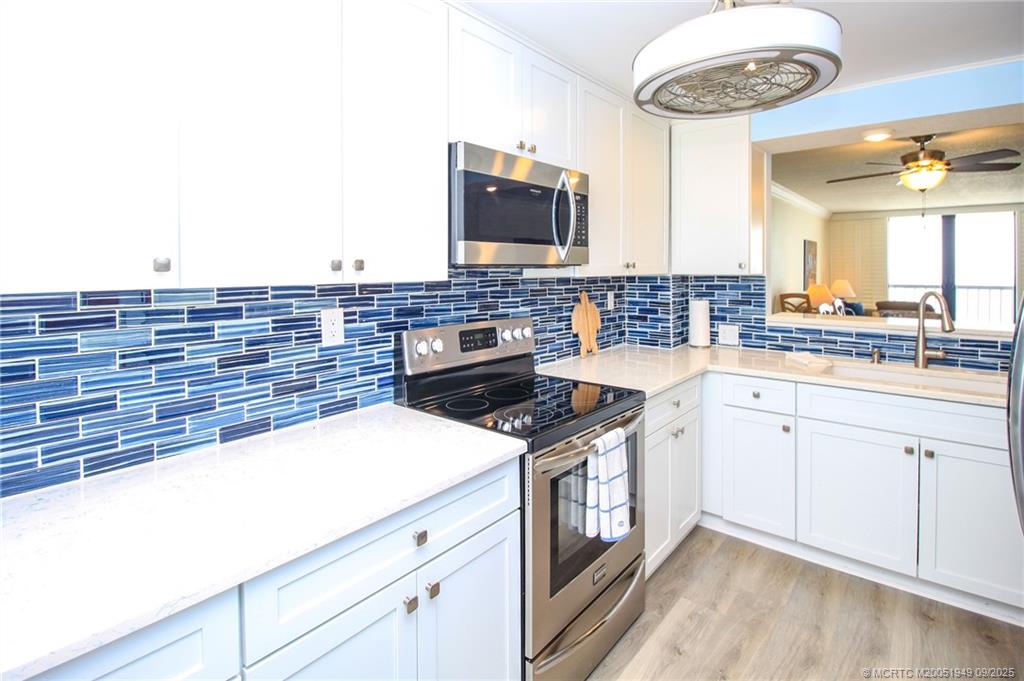 10680 South Ocean Drive, Unit 705 Jensen Beach, FL 34957 - Photo 14 of 45 a kitchen with stainless steel appliances granite countertop a stove and a microwave