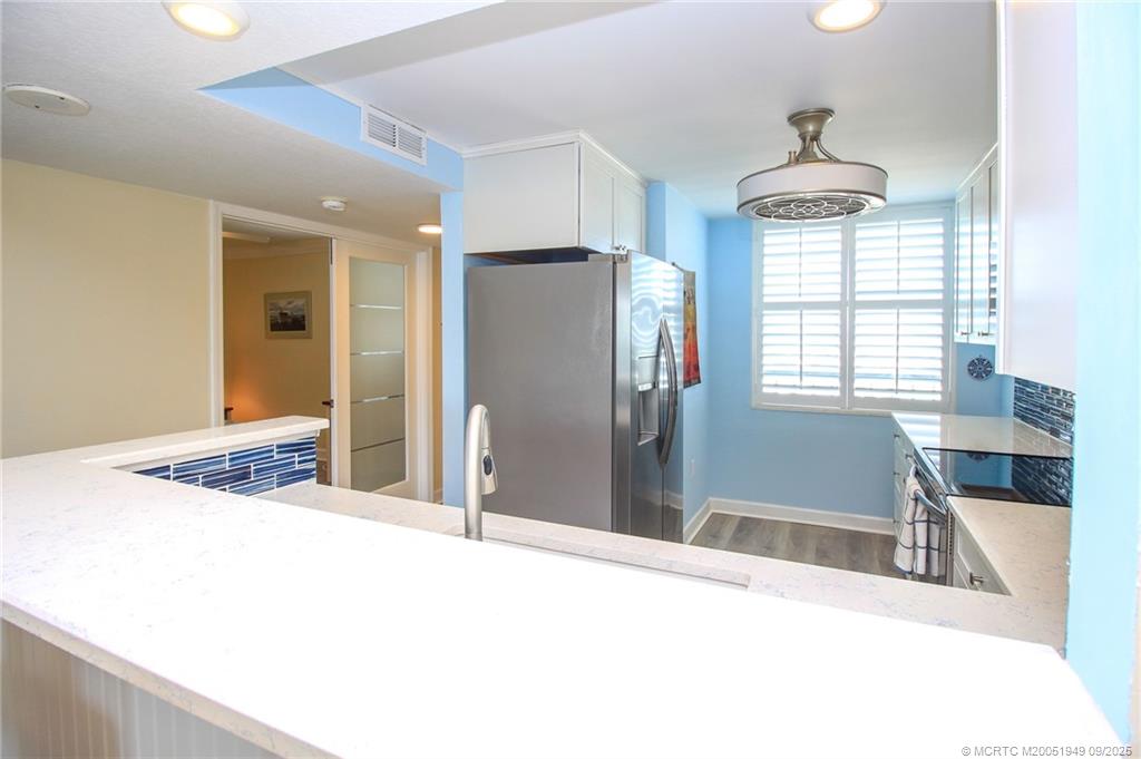 10680 South Ocean Drive, Unit 705 Jensen Beach, FL 34957 - Photo 15 of 45 a kitchen with stainless steel appliances kitchen island granite countertop a refrigerator and a sink