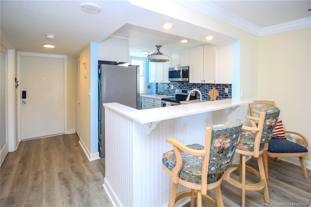 10680 South Ocean Drive, Unit 705 Jensen Beach, FL 34957 - Photo 5 of 45 a kitchen with kitchen island stainless steel appliances a sink and cabinets