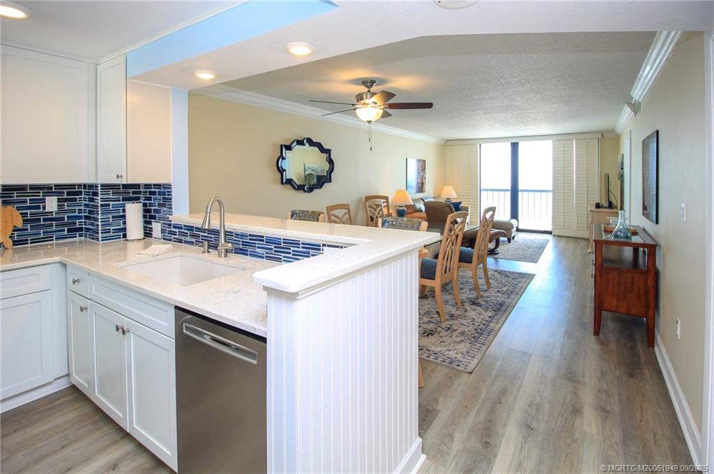 10680 South Ocean Drive, Unit 705 Jensen Beach, FL 34957 - Photo 6 of 45 a large kitchen with kitchen island a large counter space a sink appliances and living room view