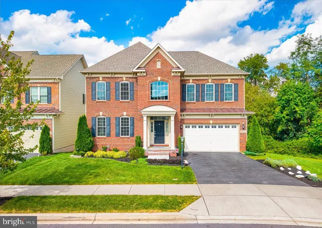 a front view of a house with a yard and potted plants