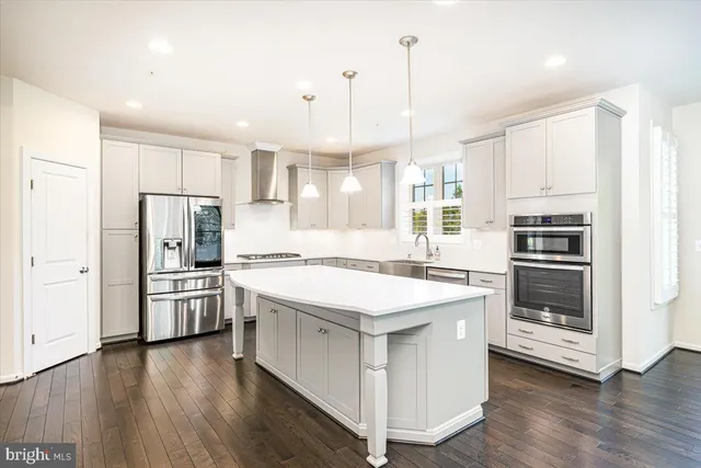 a kitchen with stainless steel appliances granite countertop a refrigerator and a stove top oven