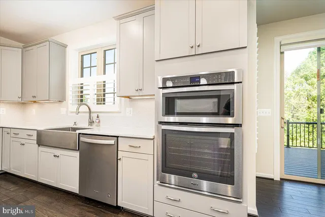 an empty room with wooden floor fireplace and windows
