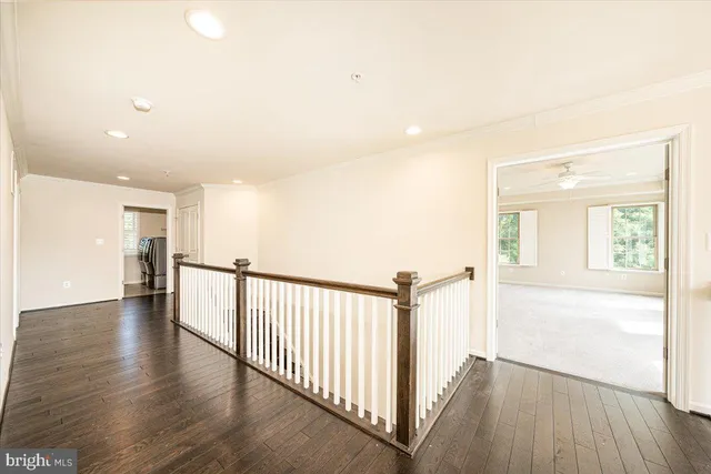 a view of an empty room with windows and chandelier fan
