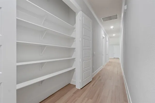 a view of a hallway with wooden floor