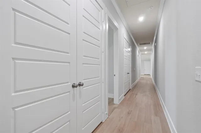 a view of a hallway with wooden floor and closet