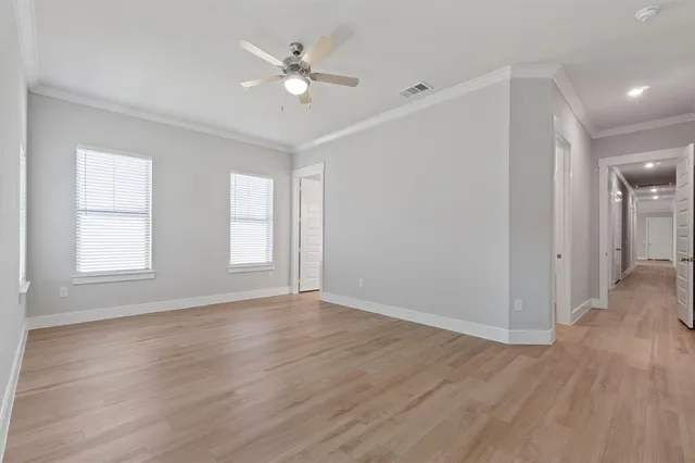 an empty room with wooden floor and window