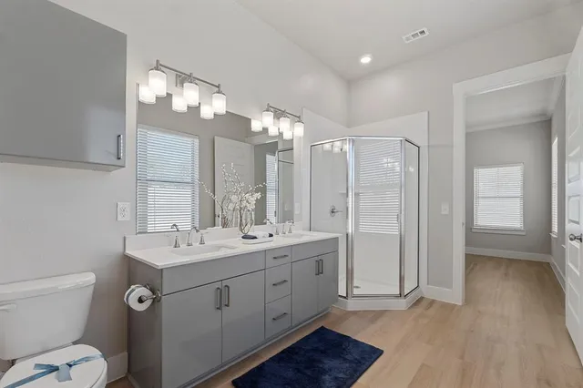 a spacious bathroom with a double vanity sink a mirror and a shower