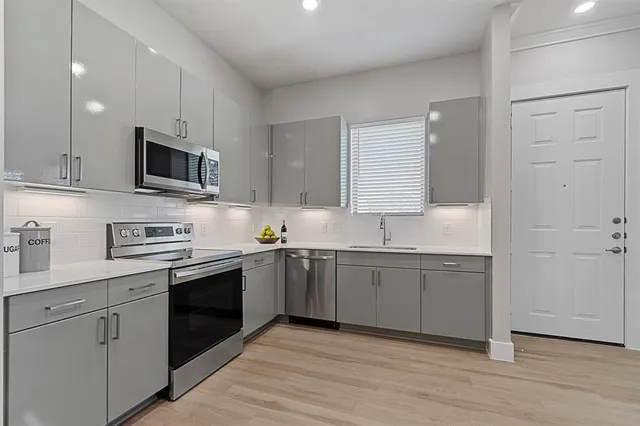 a kitchen with granite countertop cabinets stainless steel appliances and a sink