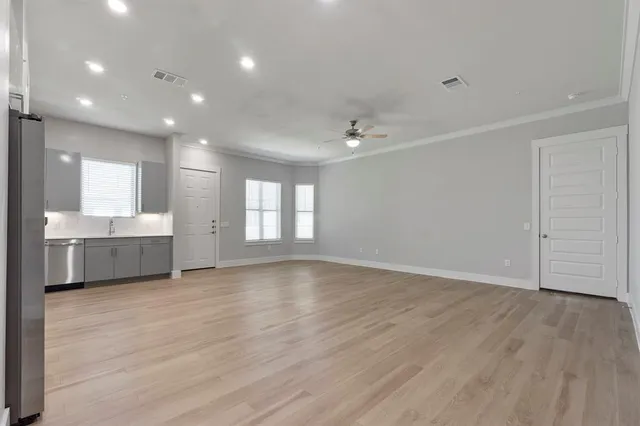 a view of an empty room with window and wooden floor