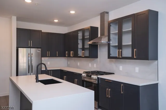 a kitchen with stainless steel appliances a sink stove and refrigerator