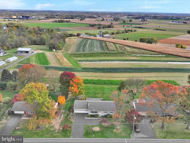 an aerial view of a house with a garden and lake view