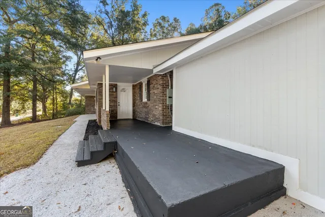 an empty room with wooden floor fireplace and windows