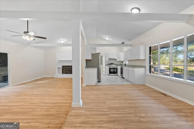 a view of empty room with wooden floor and fireplace