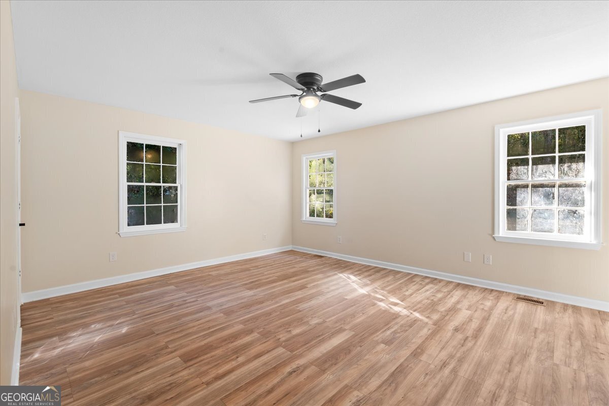 126 Waterfront Way Warner Robins, GA 31093 - Photo 23 of 60 a view of an empty room with a window and wooden floor