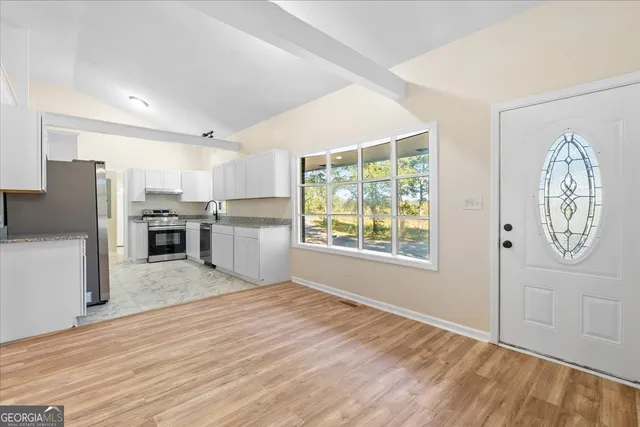 a kitchen with stainless steel appliances granite countertop a refrigerator and a sink