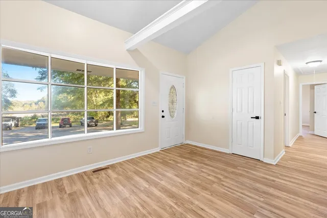 a view of empty room with wooden floor