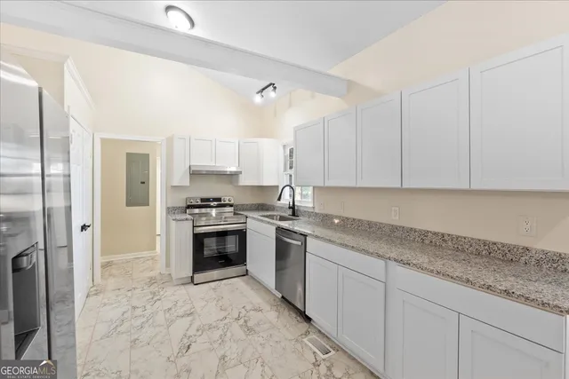 a view of an empty room with wooden floor fireplace and a window