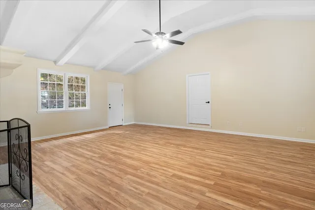 a view of an empty room with chandelier fan