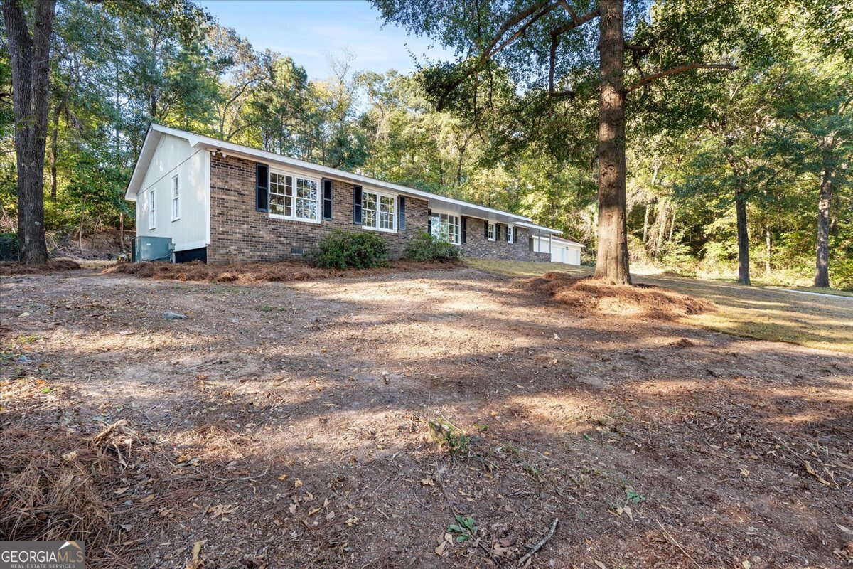 126 Waterfront Way Warner Robins, GA 31093 - Photo 9 of 60 a front view of a house with a yard and trees