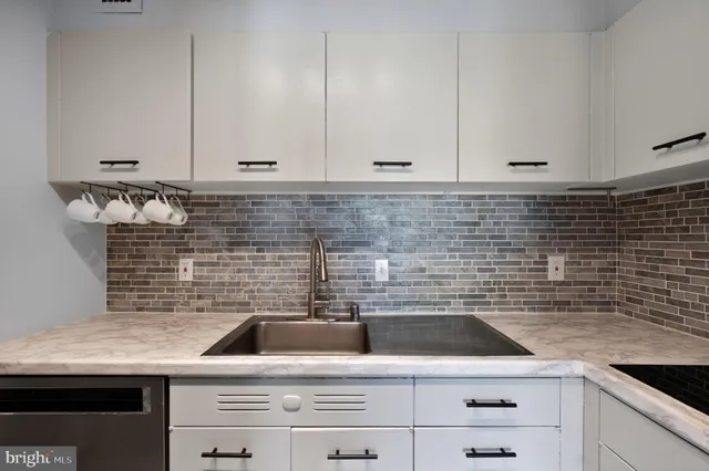 a kitchen with granite countertop white cabinets and sink