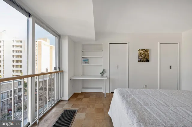 a bedroom with a bed and a large window