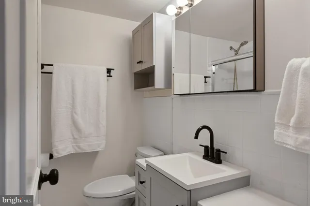 a bathroom with a toilet sink and mirror