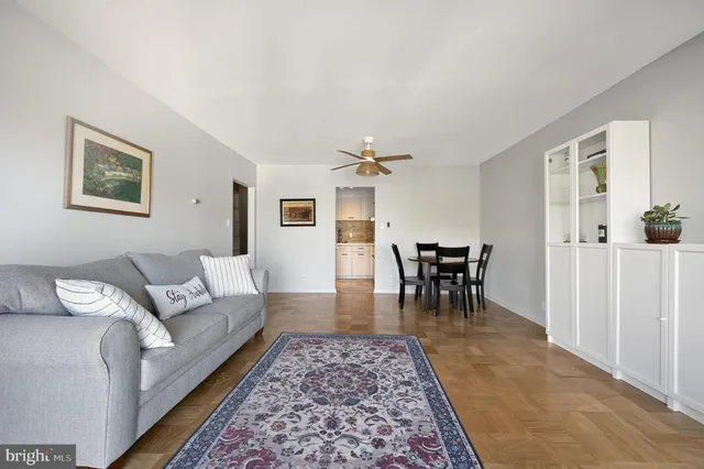 a living room with furniture and a dining table with rug