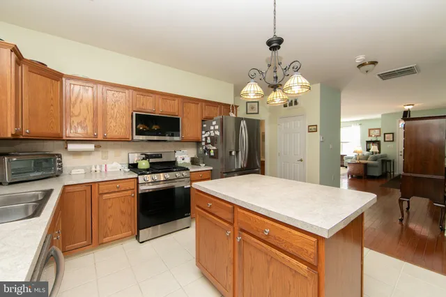 a kitchen with stainless steel appliances granite countertop a sink dishwasher stove top oven and refrigerator