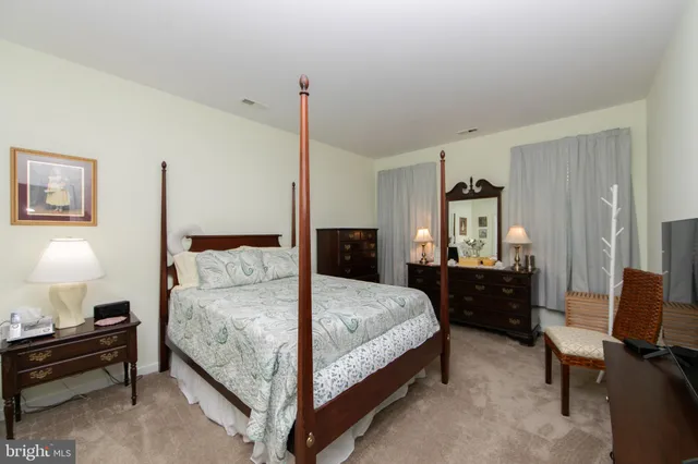 a bedroom with a bed and dresser with mirror