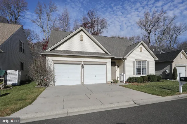 a view of a house with a yard and potted plants
