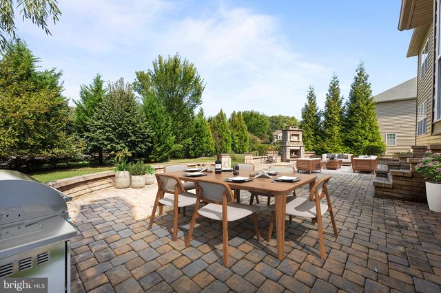 a view of a patio with dining table and chairs with plants and trees