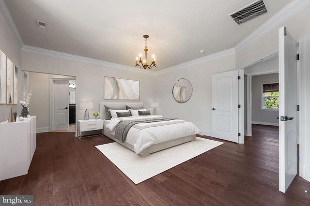 a bedroom with a large bed and a chandelier