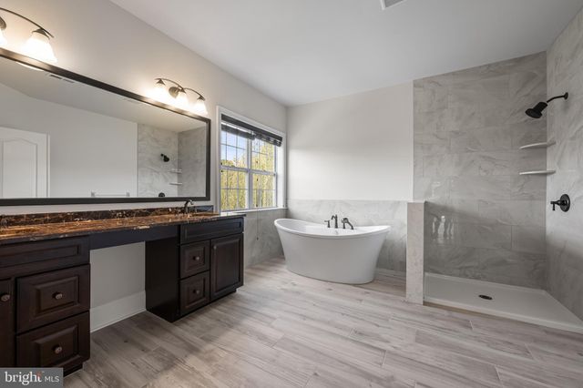 a large bathroom with a tub sink shower and mirror