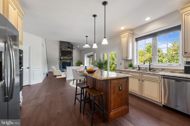 a kitchen with stainless steel appliances granite countertop table chairs and a large refrigerator