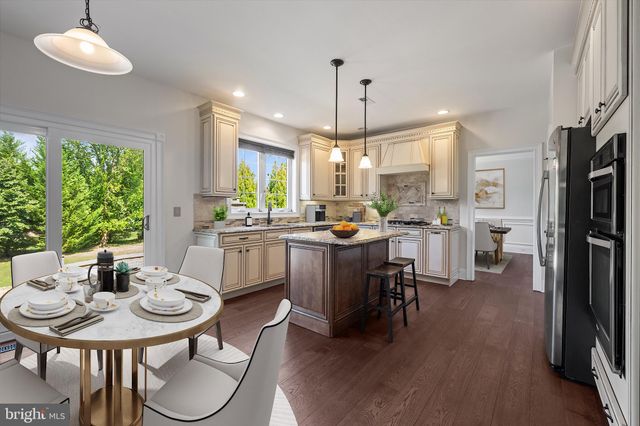 a kitchen with a dining table chairs stainless steel appliances and windows