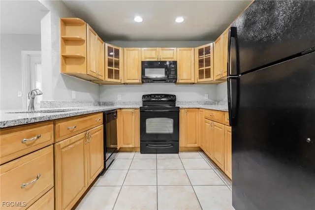 a kitchen with granite countertop a refrigerator and a stove top oven
