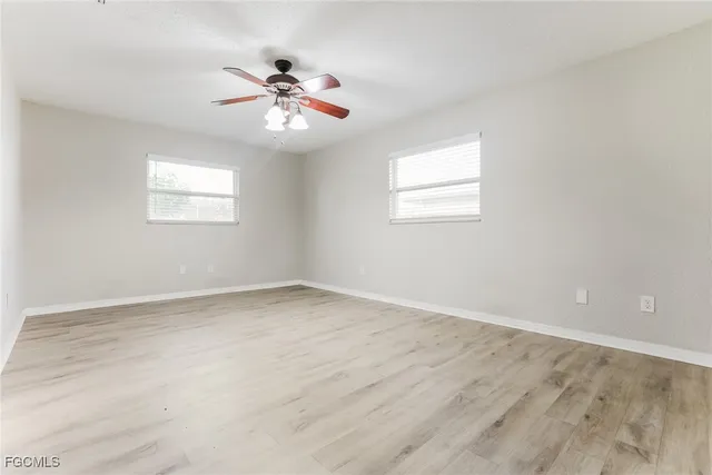 an empty room with a window and a fan