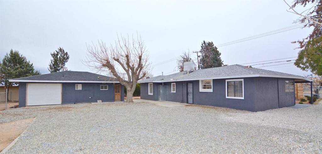 14946 Ranchero Road Hesperia, CA 92345 - Photo 1 of 1 a front view of a house with a yard and garage