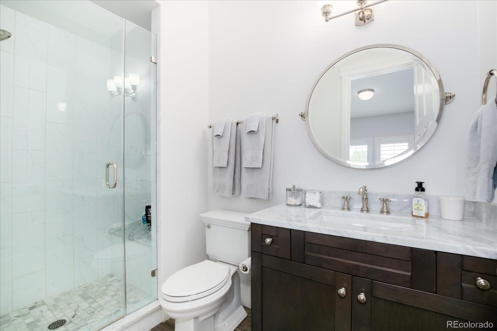 10890 Rainribbon Road Highlands Ranch, CO 80126 - Photo 26 of 40 a bathroom with a toilet a sink and mirror