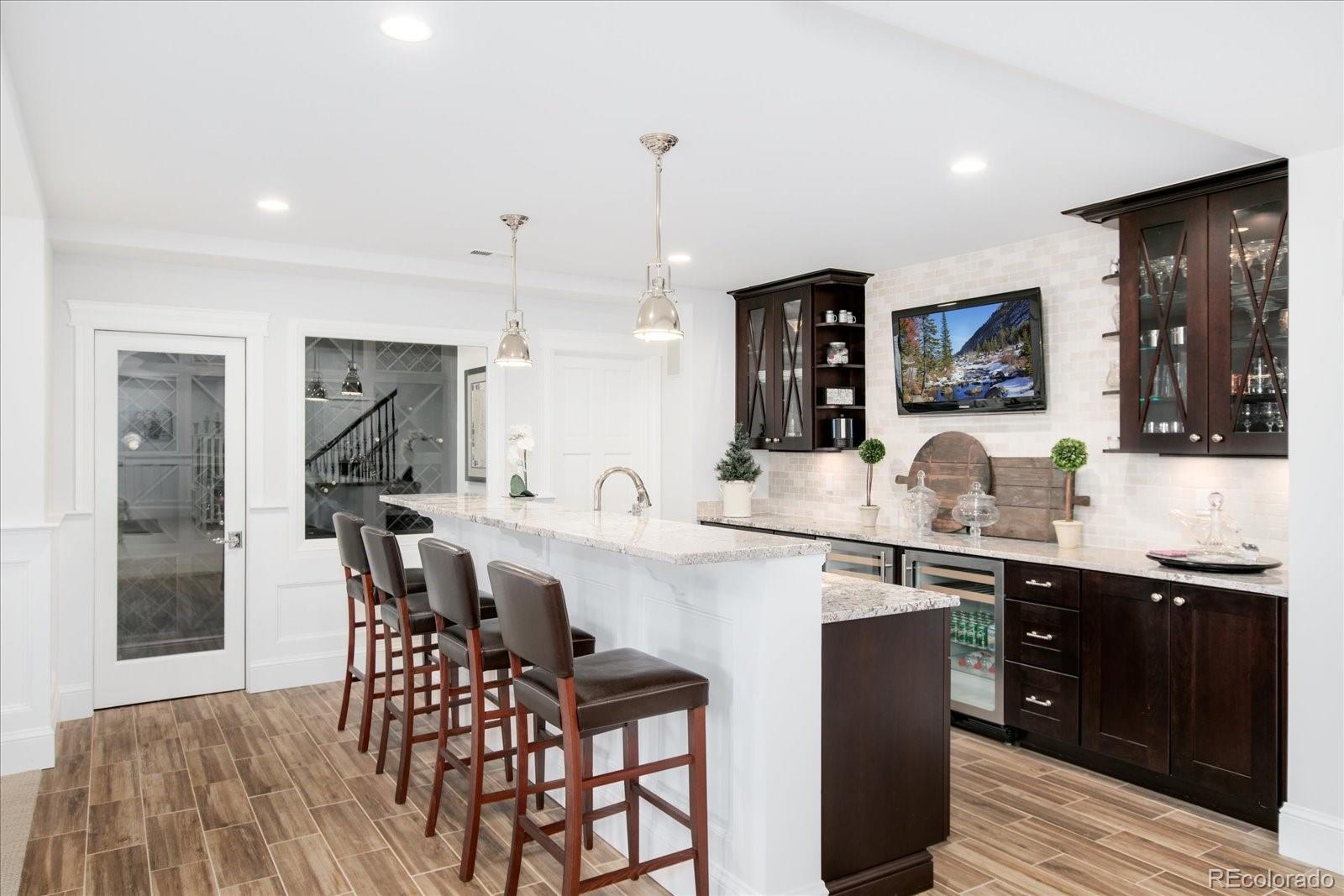 10890 Rainribbon Road Highlands Ranch, CO 80126 - Photo 30 of 40 a kitchen with a table chairs refrigerator and cabinets