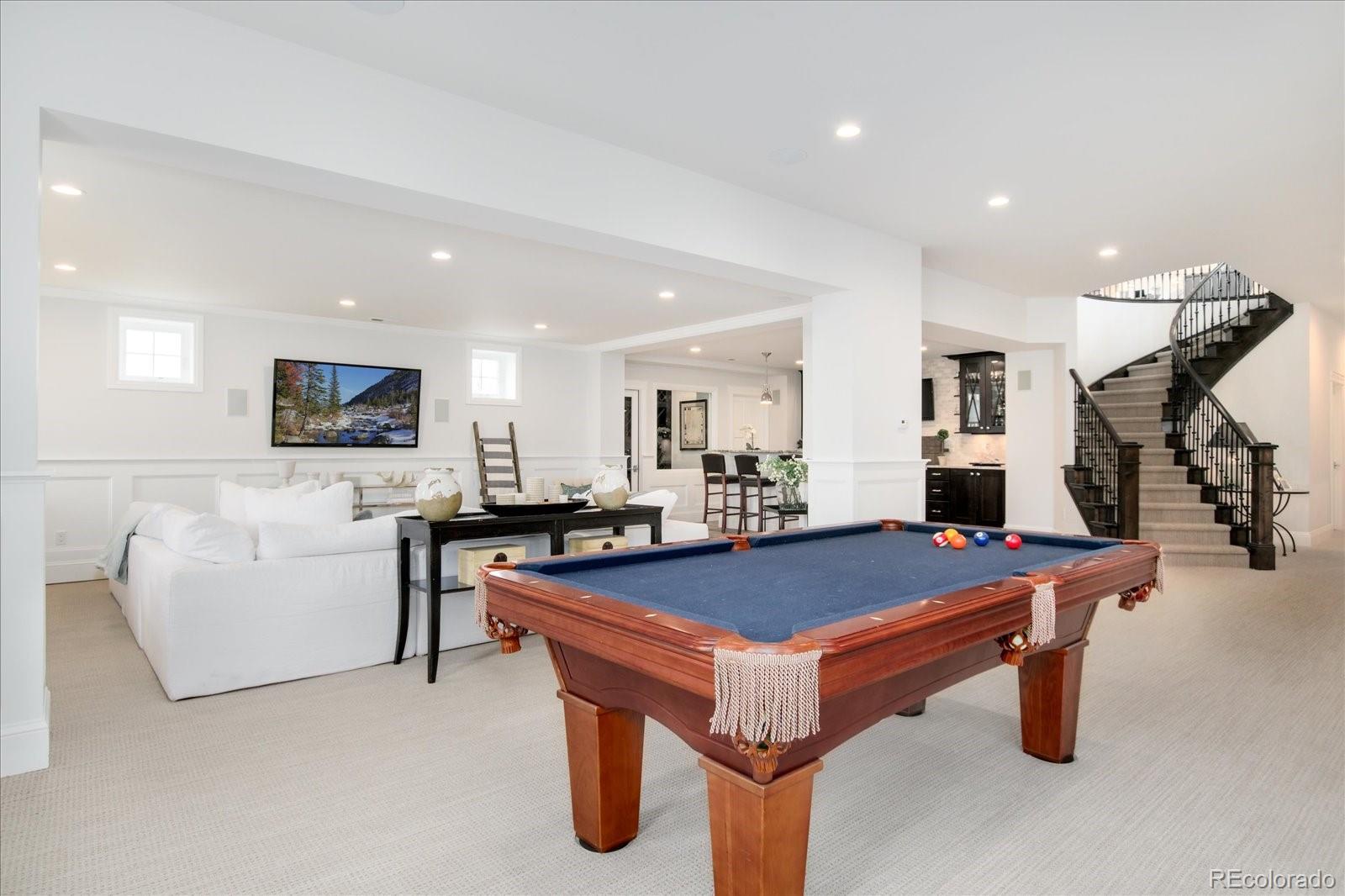 10890 Rainribbon Road Highlands Ranch, CO 80126 - Photo 33 of 40 a room with table tennis table tennis table a flat screen tv couches and a flat screen tv