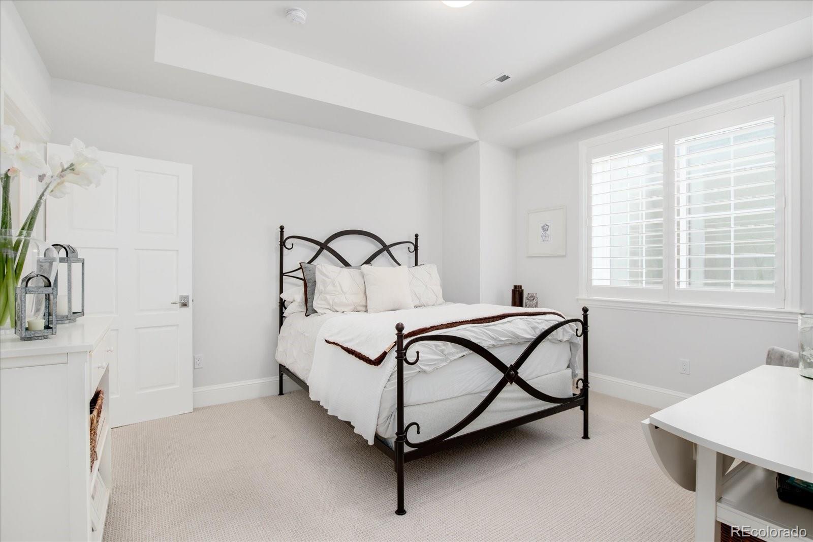 10890 Rainribbon Road Highlands Ranch, CO 80126 - Photo 39 of 40 a bedroom with a bed and a table in it