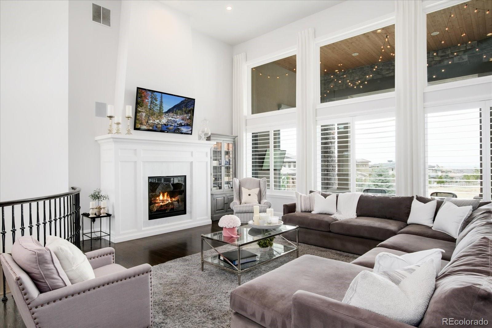 10890 Rainribbon Road Highlands Ranch, CO 80126 - Photo 6 of 40 a living room with furniture tv and a fireplace